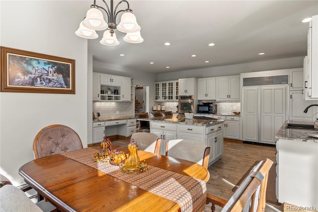 dining room with a chandelier, recessed lighting, and wood finished floors