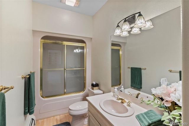 bathroom with shower / bath combination with glass door, baseboard heating, toilet, vanity, and wood finished floors