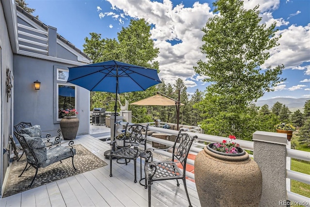 deck featuring a grill and outdoor dining space