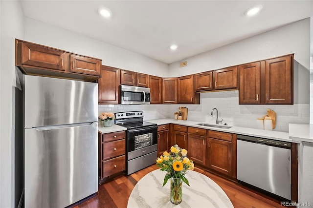 875 E 78th Ave Unit 9-2, Denver, CO 80229 - kitchen with appliances with stainless steel finishes, light countertops, tasteful backsplash, dark wood-style flooring, and recessed lighting