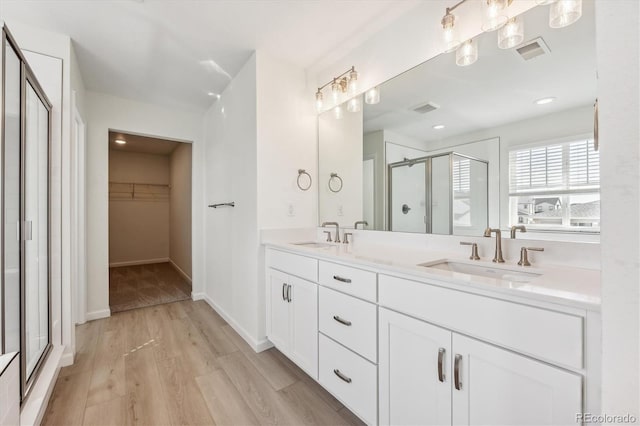 bathroom featuring vanity, hardwood / wood-style flooring, and a shower with door