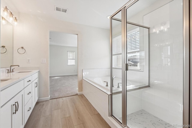 bathroom with shower with separate bathtub, hardwood / wood-style floors, and vanity