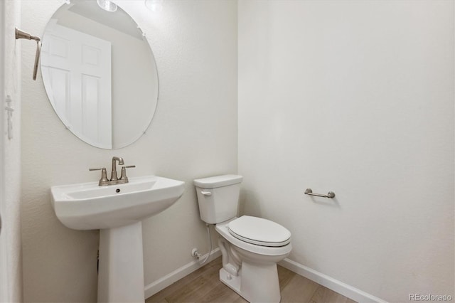 bathroom featuring wood-type flooring and toilet