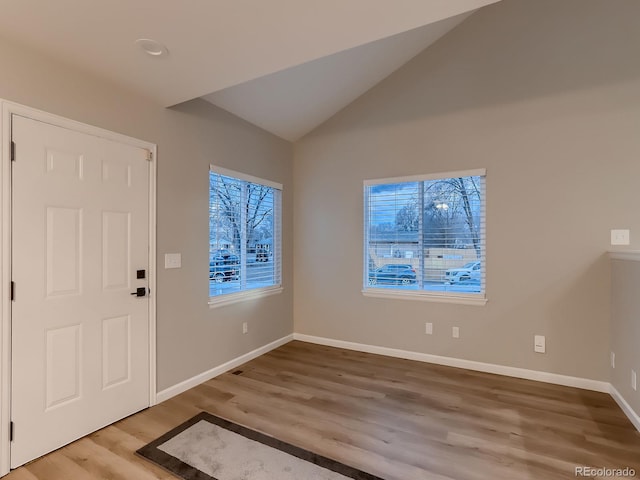 entrance foyer with vaulted ceiling, plenty of natural light, wood finished floors, and baseboards