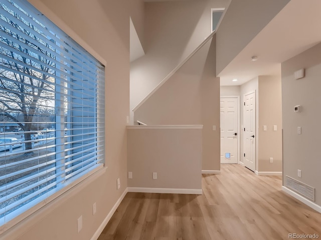 unfurnished room featuring light wood-type flooring, baseboards, and visible vents