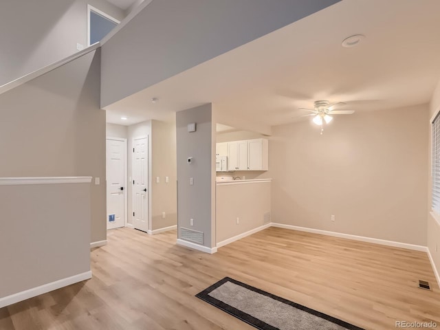 spare room featuring ceiling fan, light wood finished floors, visible vents, and baseboards