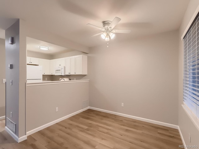 interior space featuring ceiling fan, light wood-type flooring, visible vents, and baseboards