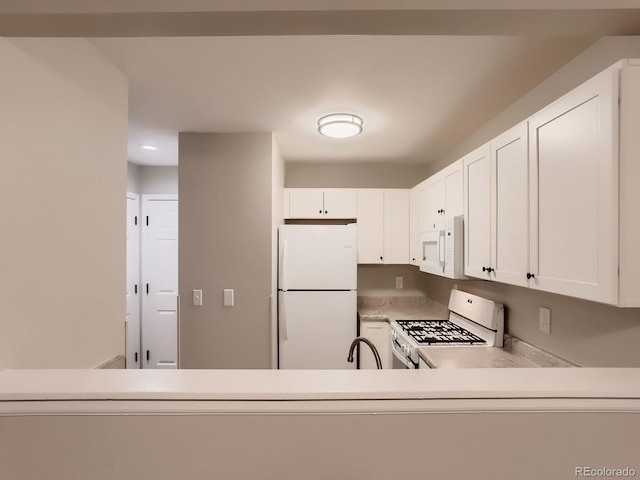 kitchen featuring light countertops, white appliances, a sink, and white cabinets