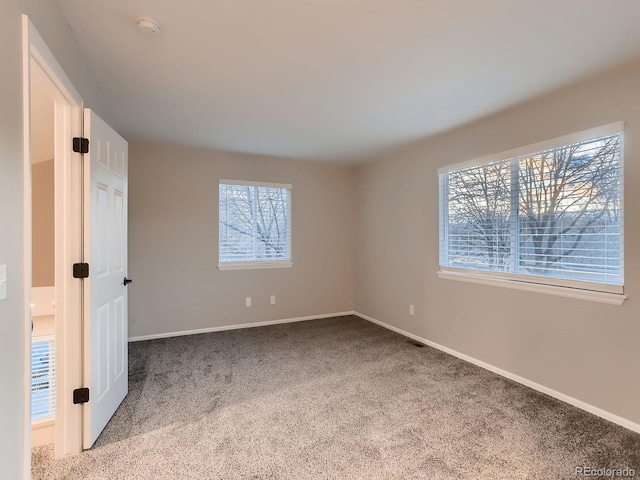 unfurnished bedroom featuring carpet floors and baseboards