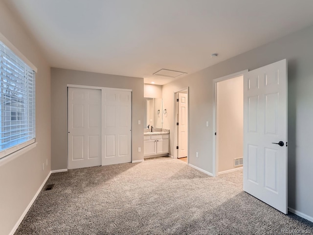 unfurnished bedroom with a sink, carpet flooring, visible vents, and baseboards