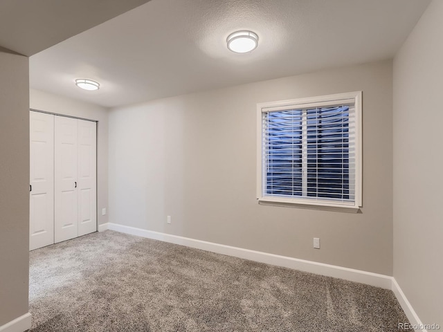 unfurnished bedroom with carpet, baseboards, and a closet