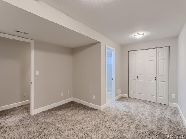 unfurnished bedroom featuring carpet floors, a closet, visible vents, and baseboards