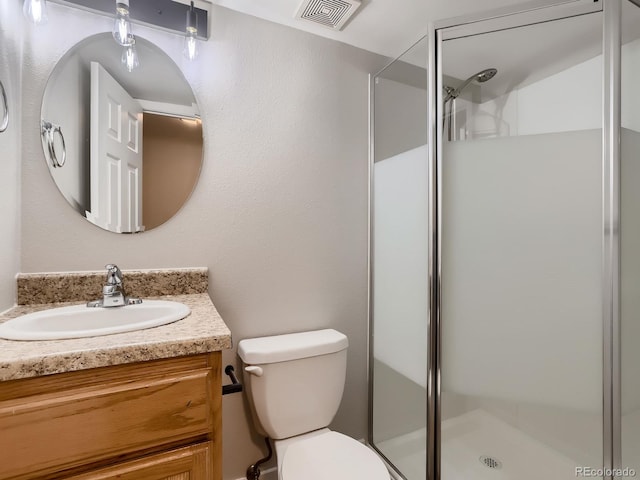 bathroom with a stall shower, visible vents, vanity, and toilet