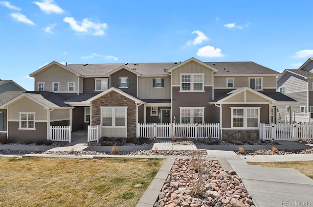 8765 Laurel Mountain Vw, Colorado Springs, CO 80924 - view of property featuring stone siding, board and batten siding, a fenced front yard, and a gate