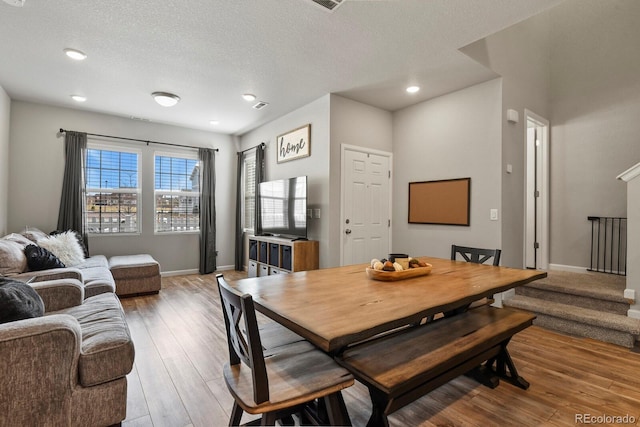 8765 Laurel Mountain Vw, Colorado Springs, CO 80924 - dining space with light wood-type flooring, a textured ceiling, stairs, and recessed lighting