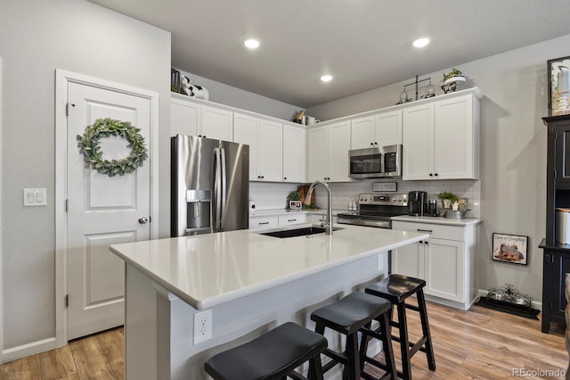 8765 Laurel Mountain Vw, Colorado Springs, CO 80924 - kitchen featuring stainless steel appliances, tasteful backsplash, light wood-type flooring, a kitchen bar, and recessed lighting