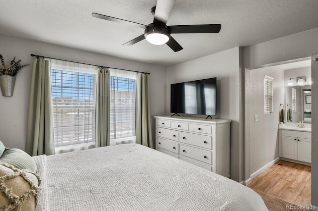 8765 Laurel Mountain Vw, Colorado Springs, CO 80924 - bedroom with light wood-type flooring, ensuite bathroom, a ceiling fan, and a textured ceiling