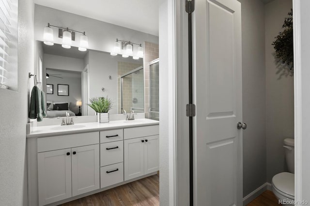 8765 Laurel Mountain Vw, Colorado Springs, CO 80924 - full bathroom featuring a stall shower, ensuite bath, double vanity, wood finished floors, and ceiling fan