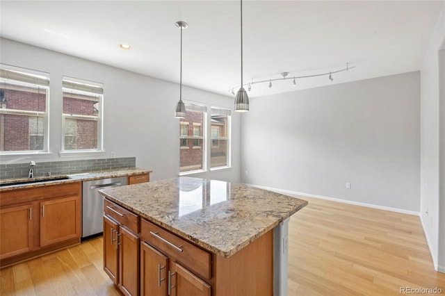 8987 E Otero Pl, Centennial, CO 80112 - kitchen featuring stainless steel dishwasher, light wood-style floors, brown cabinetry, light stone countertops, and a kitchen island