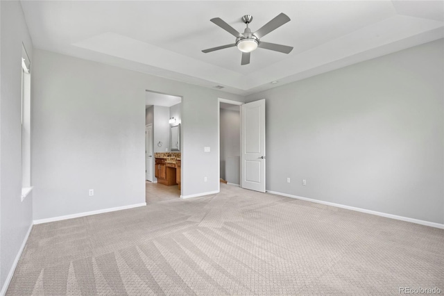 8987 E Otero Pl, Centennial, CO 80112 - unfurnished bedroom with a tray ceiling, light carpet, ensuite bathroom, and ceiling fan