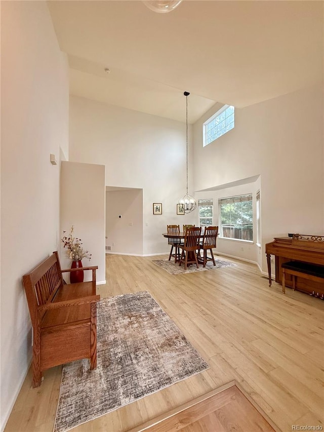 16063 E 106th Ct, Commerce City, CO 80022 - dining area with a high ceiling, light wood finished floors, baseboards, and a chandelier