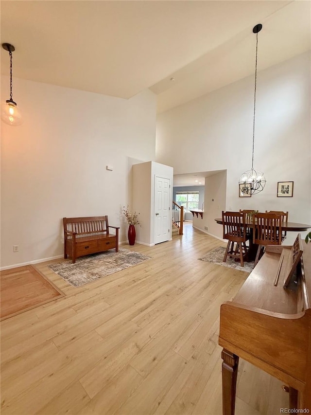 16063 E 106th Ct, Commerce City, CO 80022 - living area with light wood finished floors, a towering ceiling, a chandelier, and baseboards