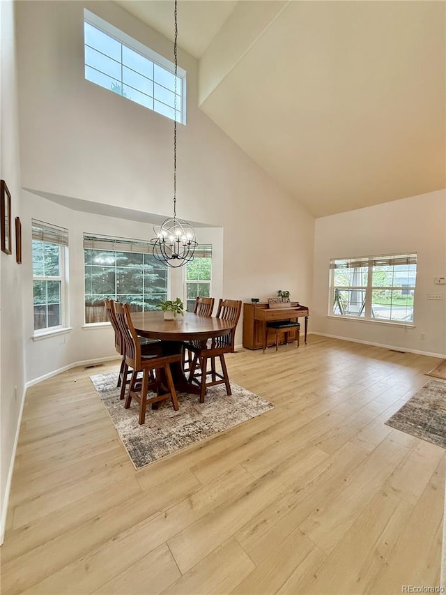 16063 E 106th Ct, Commerce City, CO 80022 - dining space featuring high vaulted ceiling, light wood-style flooring, baseboards, and a chandelier