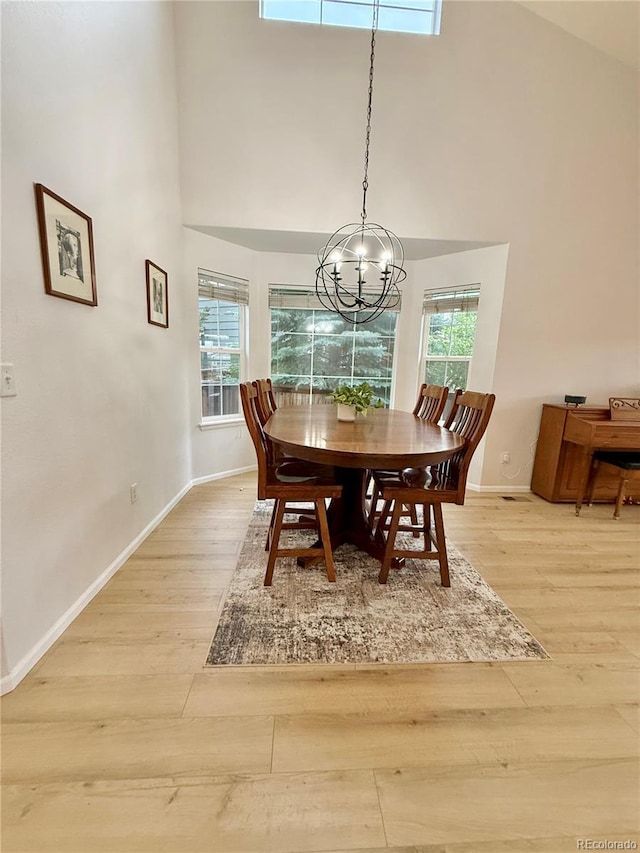 16063 E 106th Ct, Commerce City, CO 80022 - dining room with light wood-type flooring, a towering ceiling, baseboards, and a chandelier