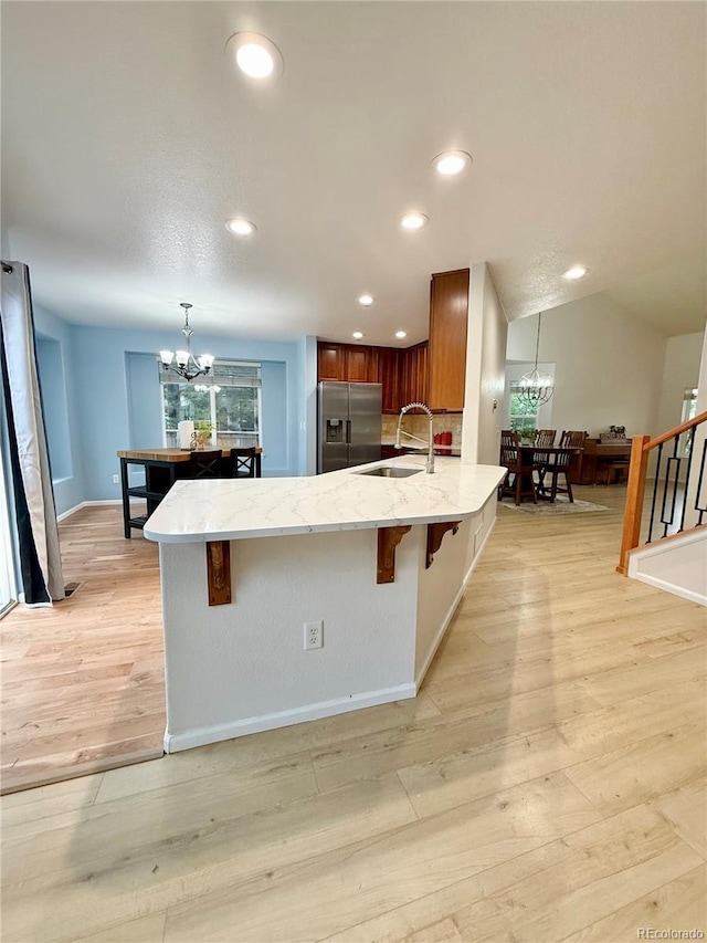 16063 E 106th Ct, Commerce City, CO 80022 - kitchen featuring stainless steel fridge with ice dispenser, a chandelier, a sink, a kitchen bar, and recessed lighting