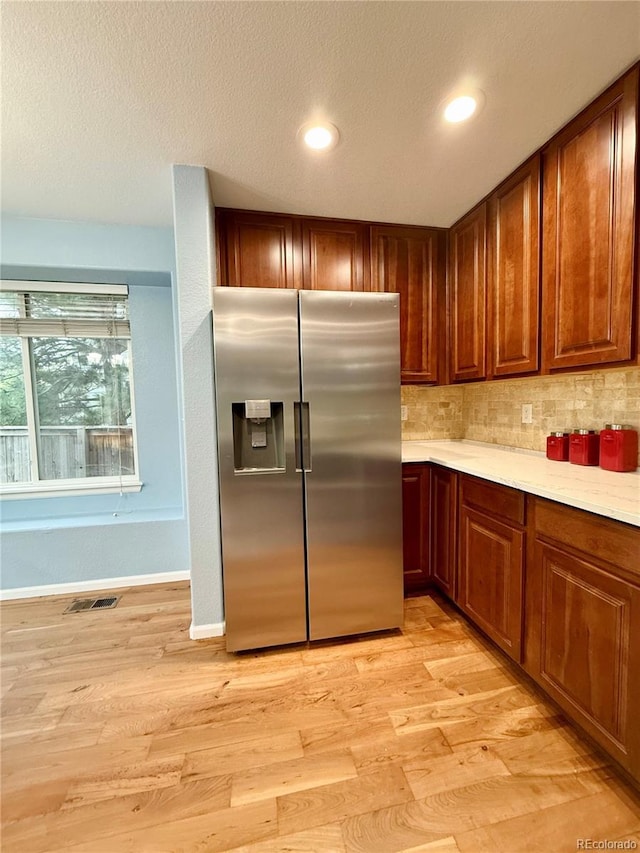 16063 E 106th Ct, Commerce City, CO 80022 - kitchen with stainless steel fridge, light wood-style flooring, light countertops, backsplash, and recessed lighting