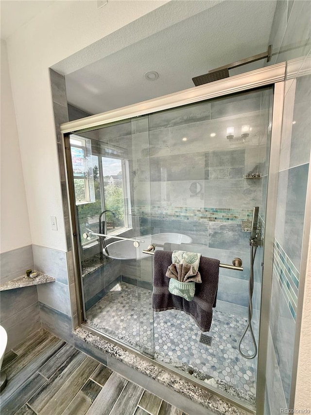 16063 E 106th Ct, Commerce City, CO 80022 - full bathroom featuring a shower stall, tile walls, and wood tiled floors