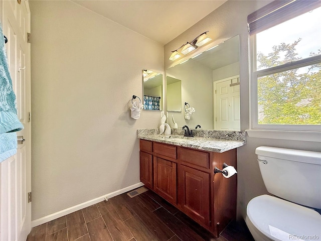 16063 E 106th Ct, Commerce City, CO 80022 - bathroom featuring vanity, wood finished floors, toilet, and baseboards