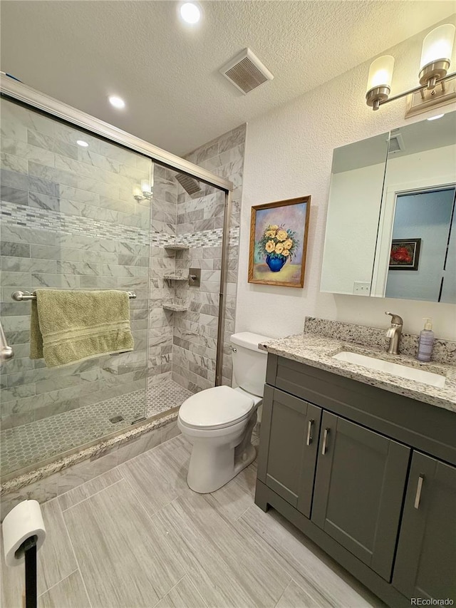 16063 E 106th Ct, Commerce City, CO 80022 - bathroom with toilet, vanity, a shower stall, a textured ceiling, and recessed lighting