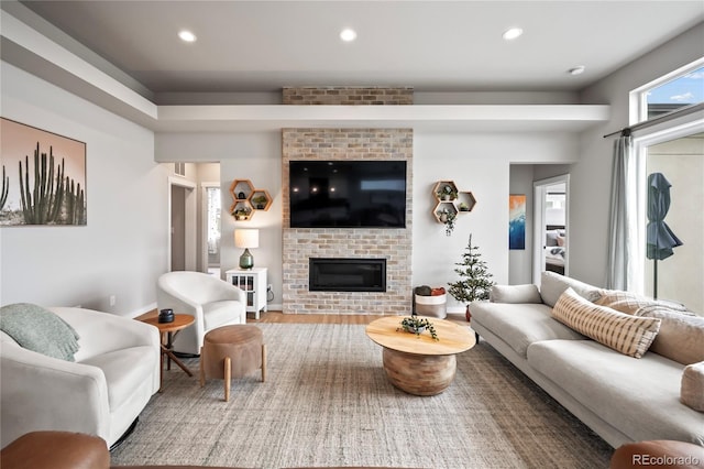 living room with hardwood / wood-style flooring and a brick fireplace