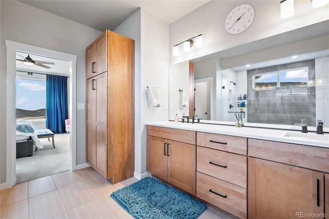 bathroom with tile patterned floors, vanity, ceiling fan, and a tile shower