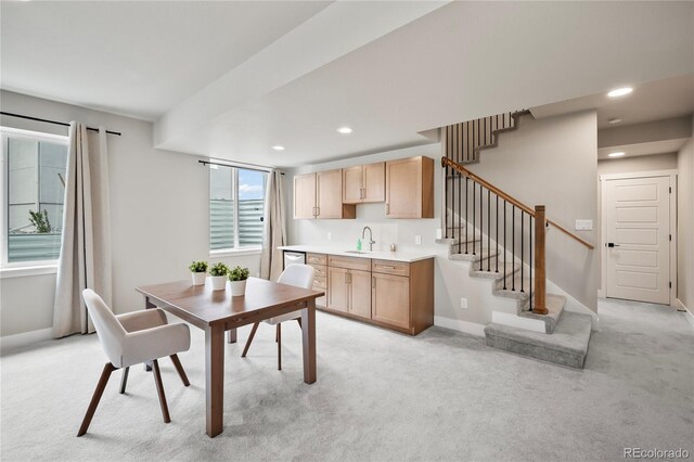 kitchen with light carpet, sink, and light brown cabinets