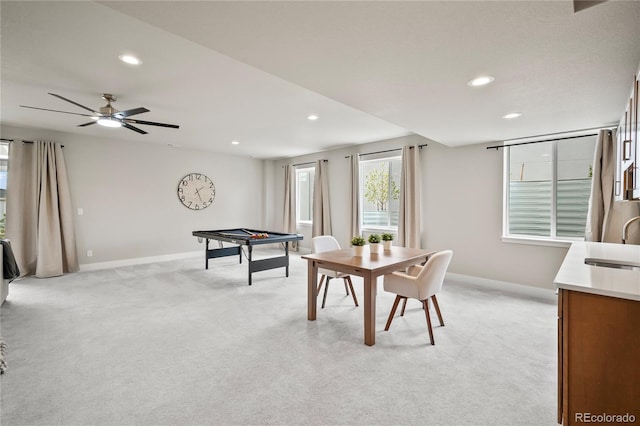 recreation room with light colored carpet, ceiling fan, and sink