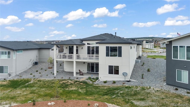 back of property featuring a patio area, a balcony, and a yard