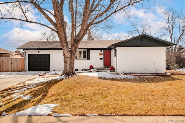 ranch-style home with a garage, concrete driveway, and fence