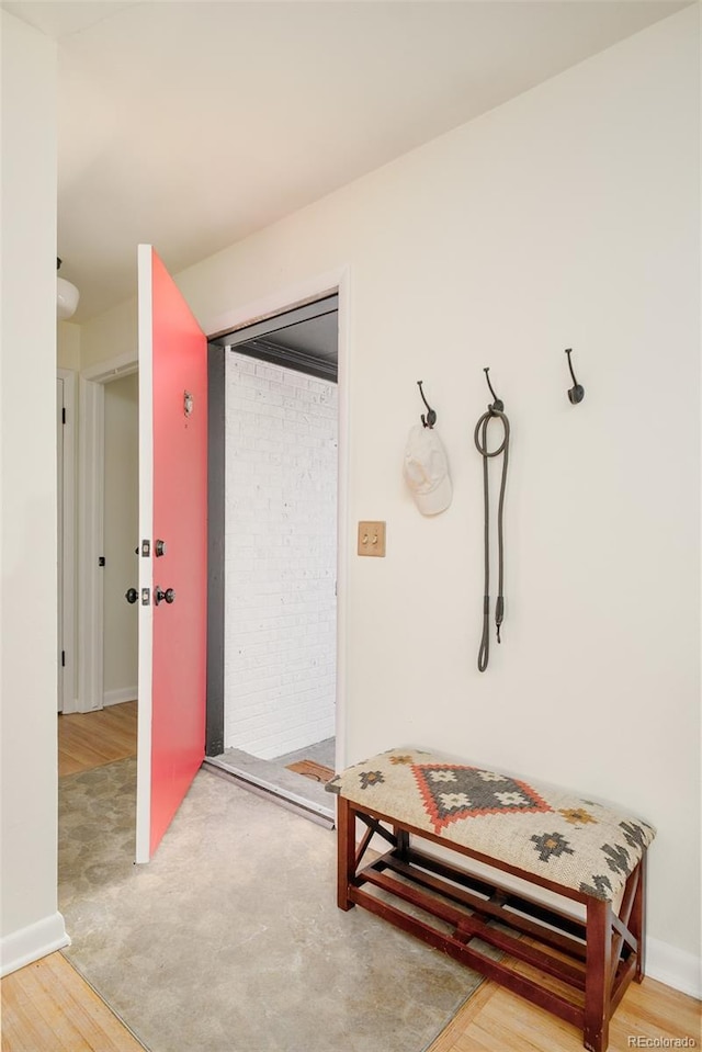 hall featuring wood finished floors and baseboards