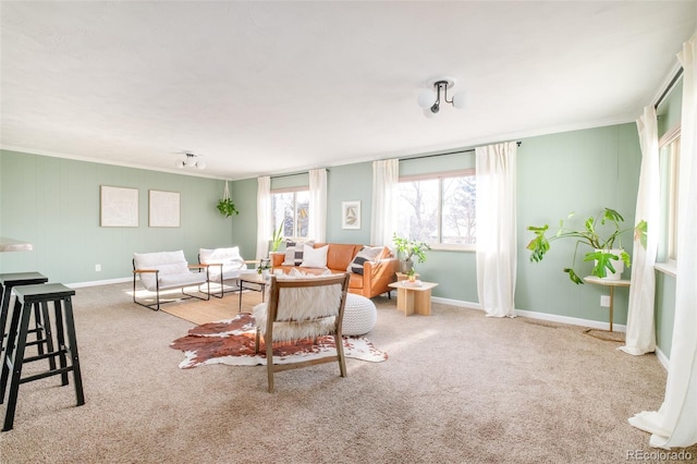 living area with ornamental molding, light colored carpet, and baseboards