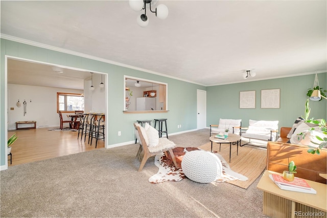 living area featuring carpet floors, ornamental molding, and baseboards