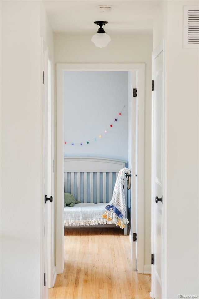 hallway with visible vents and wood finished floors