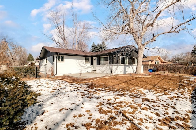 snow covered property featuring fence