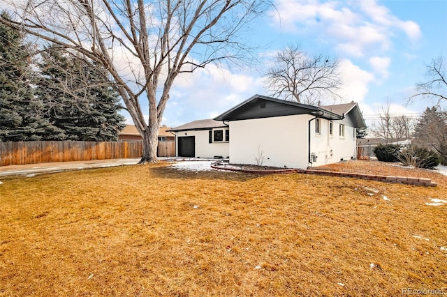 rear view of house with a lawn and fence