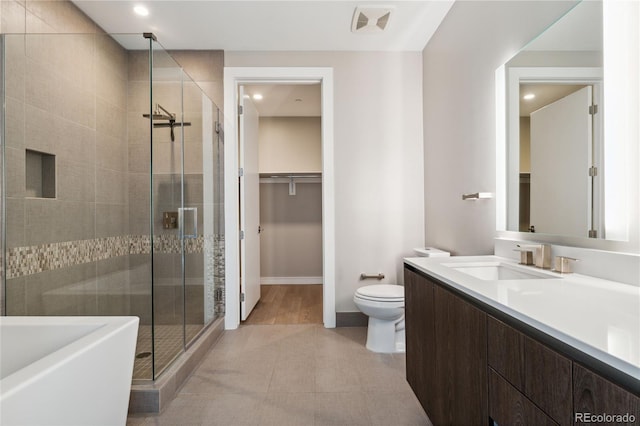 bathroom with an enclosed shower, vanity, and toilet