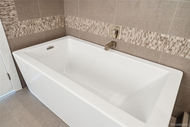 bathroom with tile patterned flooring and a bathing tub