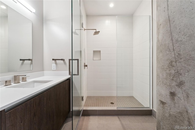 bathroom featuring tile patterned floors, vanity, and a shower with shower door