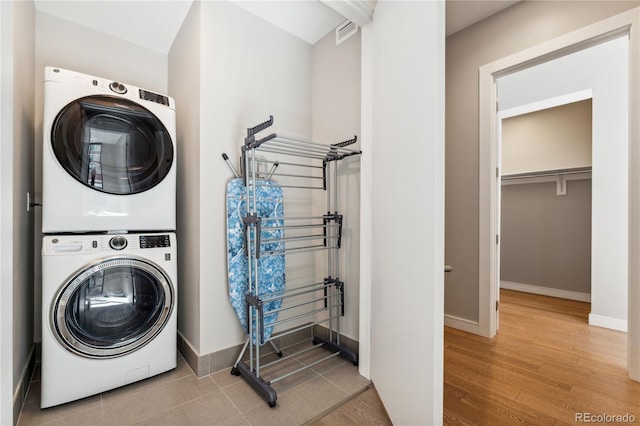 washroom featuring stacked washer / dryer and light hardwood / wood-style floors