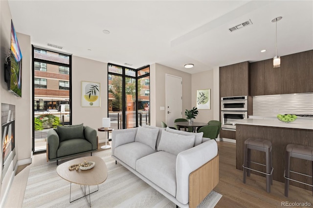 living room with light hardwood / wood-style flooring and a wall of windows